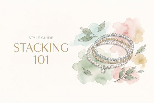 Illustration of a stack of silver, gold and pearl beaded bracelets with a small charm, among sage leaves