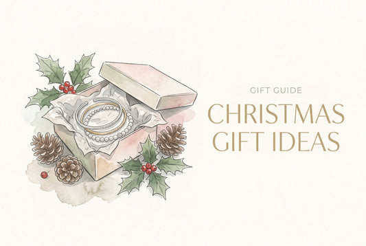 Illustration of an open gift box with silver and gold bracelets in tissue paper, with holly and pine cones